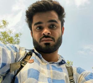 Close-up portrait of man against sky