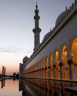 Sheikh zayed mosque with reflection in pond during sunset