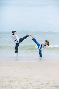 Full length of woman jumping at beach