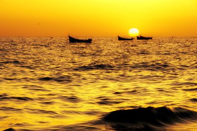 Silhouette boat in sea against sky during sunset