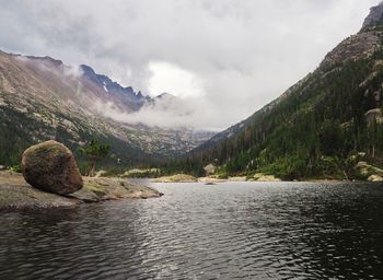 Scenic view of lake by mountains against sky