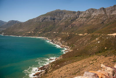 Scenic view of sea and mountains against clear sky