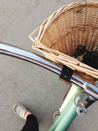 Low section of woman with bicycle standing on road