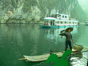 Rear view of man on boat against sky