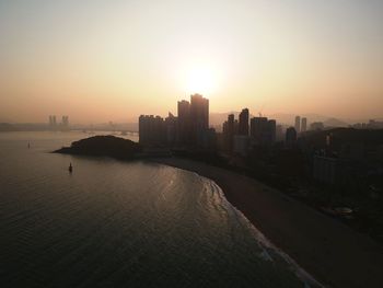 City at waterfront during sunset