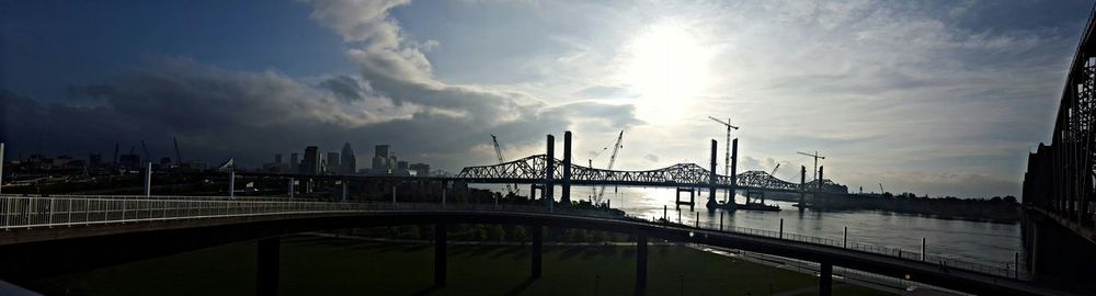 Bridge over river against cloudy sky