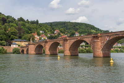 Arch bridge over river against sky