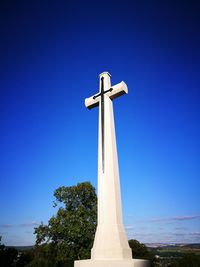 Low angle view of cross against clear blue sky