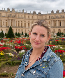 Portrait of young woman standing against buildings