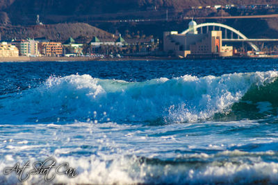 Scenic view of sea by buildings in city