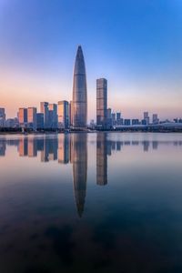 Reflection of buildings in city at sunset