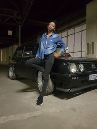 Portrait of woman standing by car