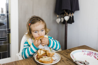 Cute girl eating food at home