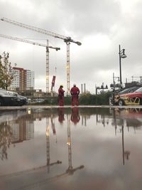 Reflection of buildings in city against sky