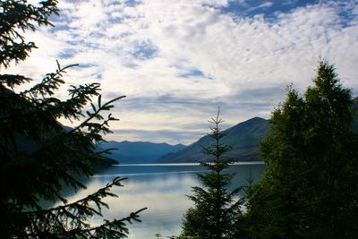 Scenic view of lake and mountains against cloudy sky