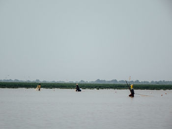 People working in water against sky