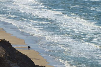 The north sea coast in denmark from the birds eye view. two people are walking on the beach