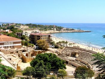 High angle view of buildings and sea against clear sky