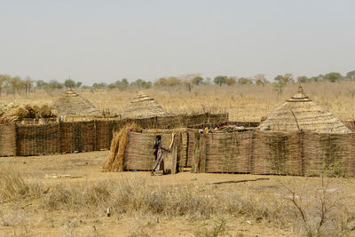 Hay bales on field against clear sky