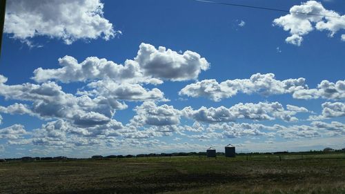 Scenic view of field against cloudy sky
