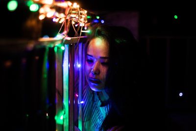 Portrait of woman looking at illuminated lights