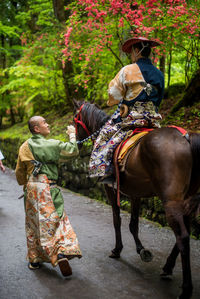 Rear view of man riding horse