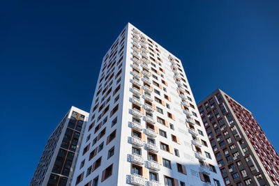 Low angle view of modern buildings against clear blue sky