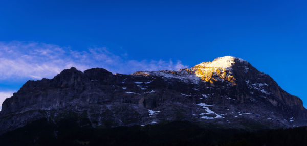 Rock formations on mountain against blue sky