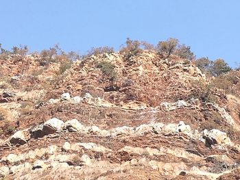 Text on rock against clear sky