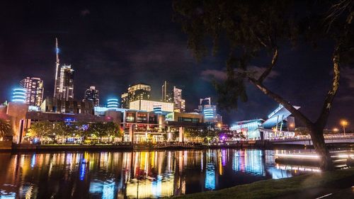 Illuminated city against sky at night