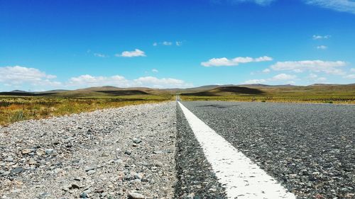 Empty country road on landscape against sky