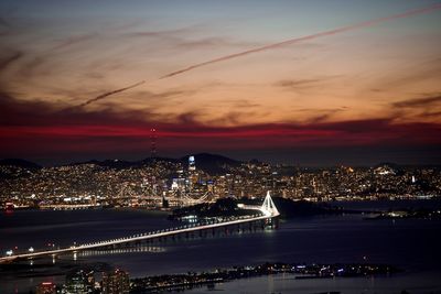 Illuminated cityscape against sky at night