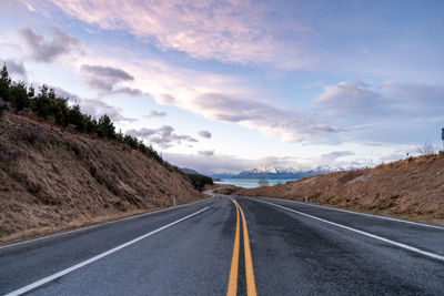 Mount cook road alongside lake pukaki with snow capped southern alps in winter evening light. 