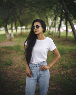 Portrait of beautiful young woman standing on land