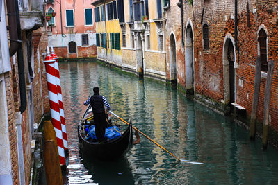 Rear view of man on gondola in canal