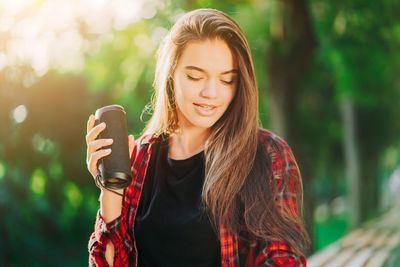 Portrait of beautiful young woman drinking outdoors