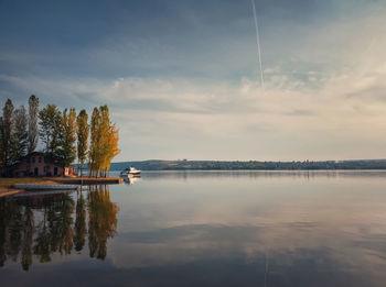 Scenic view with a house on the riverbank of nistru river and a yacht floating. autumn season scene