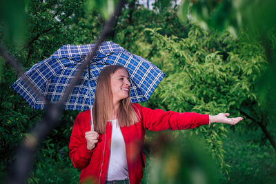 Beautiful young woman with umbrella in rain