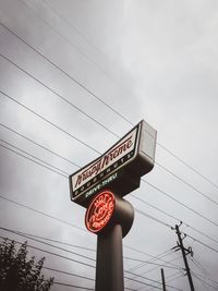 Low angle view of information sign against sky