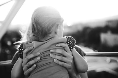 Close-up of girl holding hands against sky