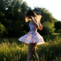 Rear view of woman standing on tree trunk