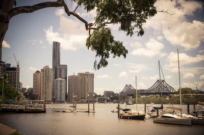 City at waterfront against cloudy sky