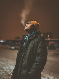 Side view of young man standing outdoors