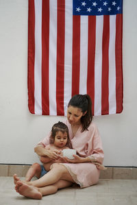 Happy girl and woman against wall