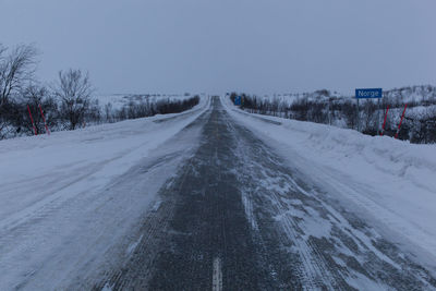 Road passing through snow covered landscape