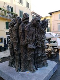 Statue by street against buildings in city