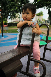 Portrait of cute girl sitting on boy looking away