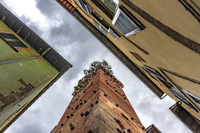 Low angle view of buildings against cloudy sky in italy