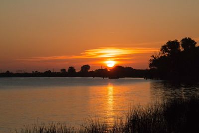 Scenic view of lake against orange sky