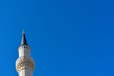 Low angle view of bell tower against blue sky